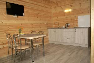 eine Küche und ein Esszimmer mit einem Tisch und Stühlen in der Unterkunft DIUNA Domki Letniskowe in Pobierowo