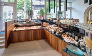a restaurant with a buffet line with food at Hotel Garni & Appartements Ilgerhof in Walchsee