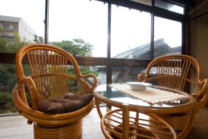 a table and two chairs and a table and a window at Ryokan Sennari (13 years or older) in Beppu