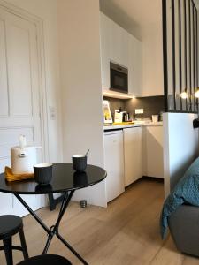 ein kleines Apartment mit einem Tisch und einer Küche in der Unterkunft Deauville centre, plage, casino et hippodrome in Deauville