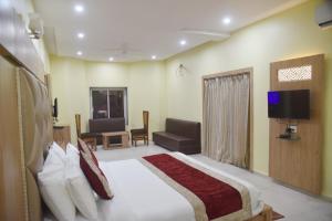 a bedroom with a bed and a tv and a couch at The River Front Resort in Sītāpur Mūāfi