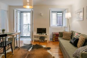 een woonkamer met een bank en een tafel bij Alfama Apartment in Lissabon