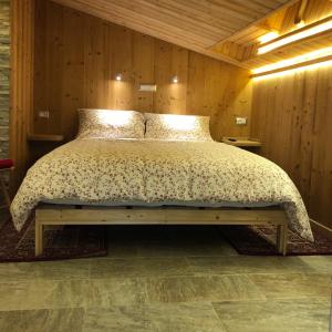 a bed in a room with a wooden wall at Le joli nid in Les Deux Alpes