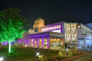 a building with purple lights on it at night at The River Front Resort in Sītāpur Mūāfi
