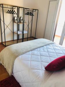 een wit bed met een rood kussen in een slaapkamer bij Baricityhouse in Bari
