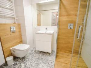 Un baño con inodoro, lavabo y ducha. en Apartament Bliżej Morza, en Kołobrzeg 21 fotos más