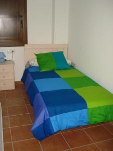 a bed with a colorful comforter in a room at Casa Vallés in Adahuesca