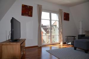 una sala de estar con TV de pantalla plana en una cómoda en Mendlers Ferienwohnung, en Wangen im Allgäu