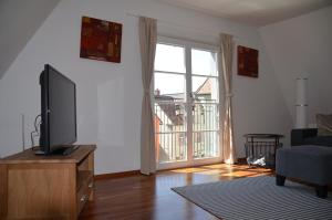 a living room with a flat screen tv on a dresser at Mendlers Ferienwohnung in Wangen im Allgäu