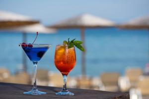 two cocktails sitting on a table next to a pool at Thasos Blue Apartments in Prinos