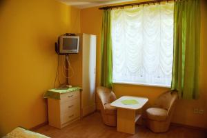 a room with a table and a tv and a window at Wilcza Chata in Kołczewo