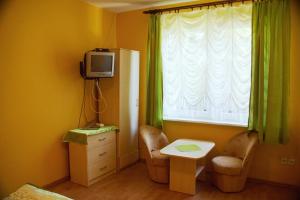 a room with a table and a tv and a window at Wilcza Chata in Kołczewo +17 photos