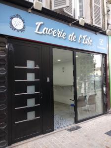 a store front with a sign that reads lacquire die ike at Gîtes de l'isle Centre-Ville - WiFi Fibre - Netflix, Disney, Amazon - Séjours Pro in Château-Thierry