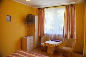 a bedroom with a bed and a table and a window at Wilcza Chata in Kołczewo