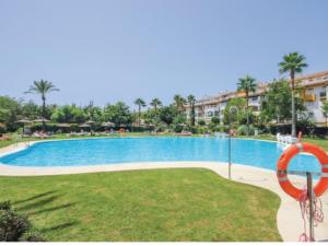 a large swimming pool in a park with a building at Dama de Noche in Marbella