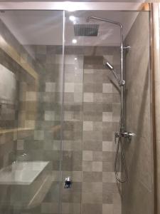 a shower with a glass door in a bathroom at Apartament Nad Potokiem in Szczawnica