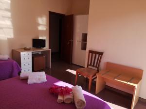 Schlafzimmer mit einem lila Bett, einem Schreibtisch und einem Stuhl in der Unterkunft Grand Hotel Aspromonte in Delianuova