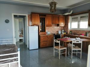 a kitchen with a table and a white refrigerator at Seven Seas Apartments in Artemida