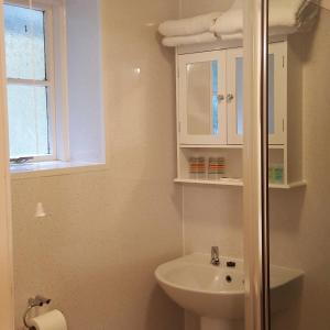 Un baño con lavabo, inodoro y ventana. en Dragon Bed and Breakfast, en Betws-y-coed