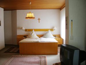 1 dormitorio con 1 cama con una cruz en la pared en Ferienhof Hoppe, en Wildewiese