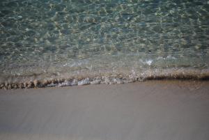 a close up of the water on the beach at Summer Beach Rooms in Fontane Bianche