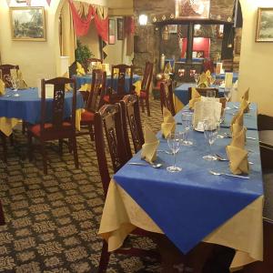 un comedor con mesas azules con servilletas. en Dragon Bed and Breakfast en Betws-y-coed