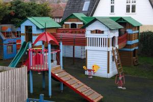 un parque infantil con tobogán y una casa de juegos en The Victory at Mersea, en West Mersea