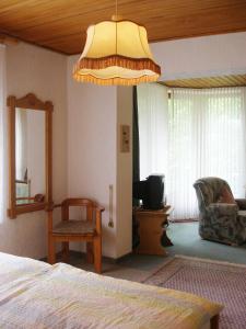 Dormitorio con cama y lámpara de araña grande en Ferienhof Hoppe en Wildewiese