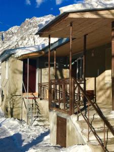 a log cabin in the snow with a balcony at Riverside Kazbegi in Stepantsminda