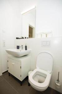 My room serviced apartment-Messe في ميونخ: حمام ابيض مع مرحاض ومغسلة