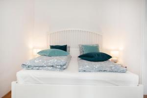 een wit bed met twee kussens erop bij CHRISTINE-2 BEDROOMS APARTMENT IN THE DOWNTOWN in Boedapest