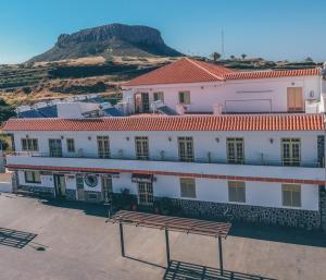 a large white building with a bench in front of it at Hotel Sonia Chipude in El Cercado