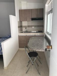 a kitchen with a counter and a table and a chair at Cavas AP in Cali