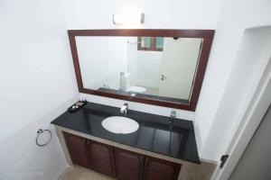 a bathroom with a sink and a mirror at Jaffna Heritage Hotel in Jaffna