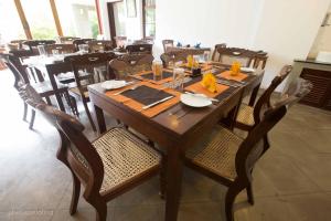 a wooden table and chairs in a restaurant at Jaffna Heritage Hotel in Jaffna