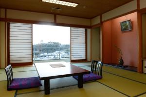 a dining room with a table and chairs and a window at Kishotei in Hirado