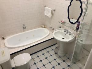 a bathroom with a tub and a toilet and a sink at Lorelei Bed & Breakfast in Portland