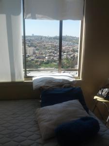 2 camas en una habitación con ventana grande en Coraceros Apartment, en Viña del Mar