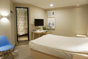 1 dormitorio con 1 cama, TV y silla en China HK Motel, en Hong Kong