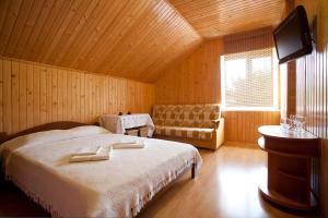 1 dormitorio con cama, sofá y TV en 4-sezona Hotel, en Alupka