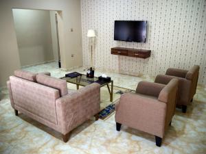 a living room with two chairs and a tv at Porto Golf Hotels in Kano