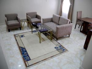 a living room with chairs and a table and a rug at Porto Golf Hotels in Kano