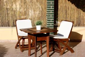 two chairs and a wooden table with a potted plant on it at Akis Apartments in Paleokastritsa
