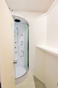 a bathroom with a shower with a glass door at Yakasoba House in Ginoza