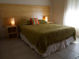 1 dormitorio con 1 cama grande y cabecero de madera en Al Mare en Monte Hermoso