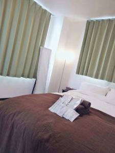 Una habitación de hotel con una cama con una bata. en Sun Hotel, en Tokio