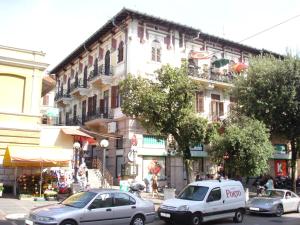 a street with cars parked in front of a building at Green Market Apartment in Opatija