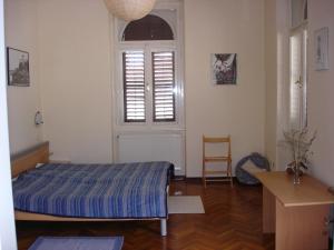 a bedroom with a bed and a window and a chair at Green Market Apartment in Opatija