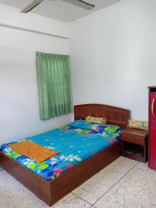 a bedroom with a bed and a green window at RC Apartment in Krabi