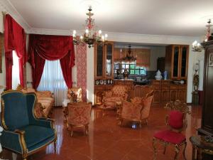 a living room with chairs and a chandelier at Castle By The Sea in Artemida